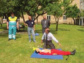 Istruttore illustra ad un volontario della Protezione Civile l'uso del defibrillatore su un manichino. Assistono il Sindaco e il coordinatore De Maio.